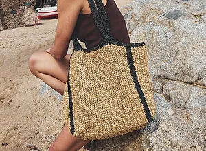 Sommerlig strandveske i strå med sorte detaljer.