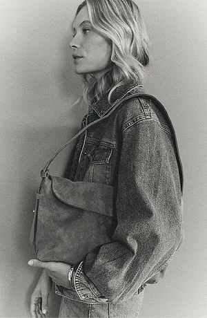 En klassisk denimjakke med nagler, kombinert med en stilren skinnveske for en avslappet stil.