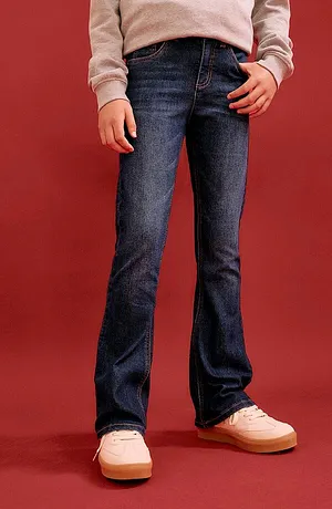 Behagelig jeans og grå genser kombinert med pastellfargede sneakers – en ledig hverdagslook.