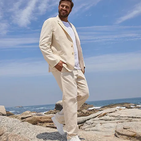 Elegant, kremfarget sommerdress: Lett blazer, hvit bukse og T-skjorte, matchende lyse sko.