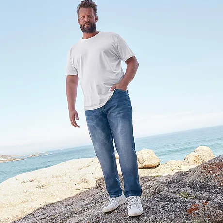 Ledig strandlook: Hvit T-skjorte og avslappet jeans kombinert med behagelige, hvite sneakers.