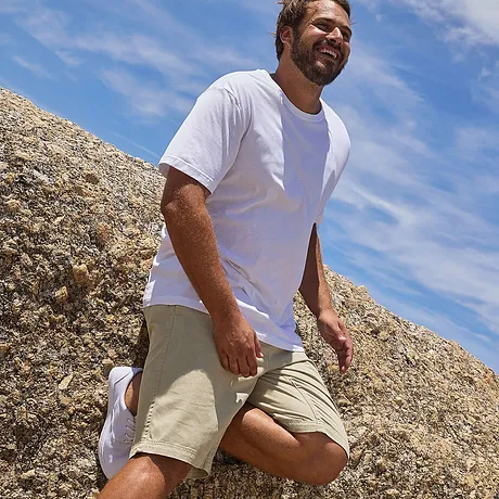 En stilren, hvit T-skjorte og beige shorts – perfekt for en solfylt dag på stranden.
