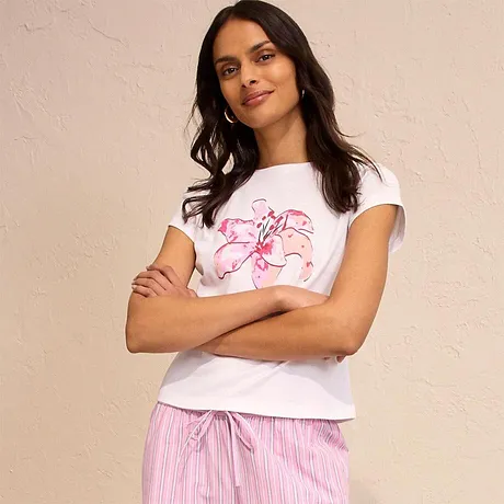 Hvit T-skjorte med rosa trykk kombinert med stripete pyjamasbukse. Behagelig og ledig look.