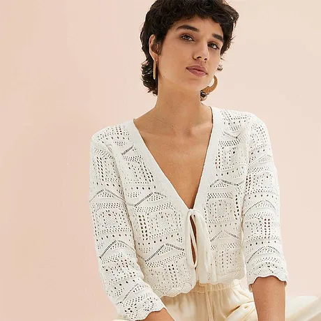 Lett, hvit cardigan med hullmønster og knapper, perfekt for sommerlige dager.