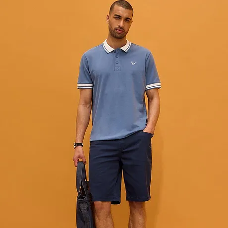 Lyseblå poloskjorte med hvit krage og mørk bukse. En sporty og elegant look til hverdagen.