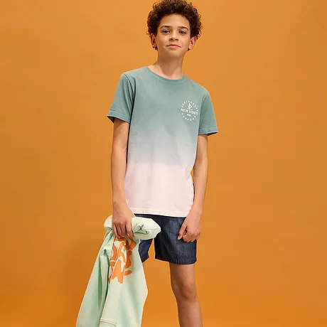 T-skjorte med fargeovergang, mørke shorts og en lett genser til å slenge over.