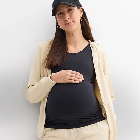 Behagelige mammaklær: kremfarget cardigan og bukse, mørk topp og sporty caps.