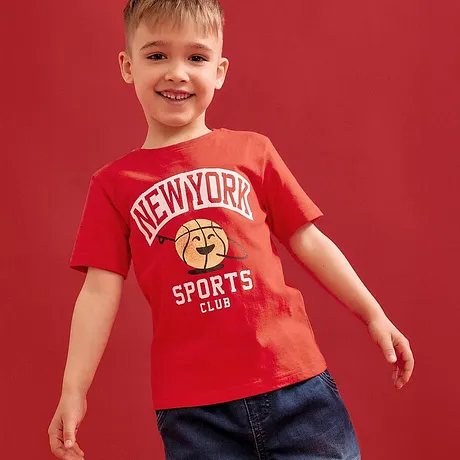 Rød T-skjorte med "New York Sports Club"-trykk kombinert med blå jeans.