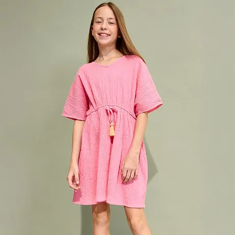 Sommerlig rosa kjole med korte ermer, snøring i midjen og dusker. Komplettert med gullfargede sandaler.