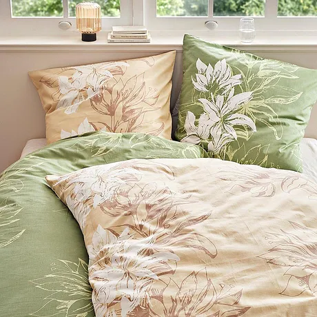 Blomstrete sengesett i pastelltoner: Grønt og beige med delikate blomstermotiver pynter sengen.