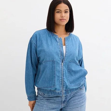 Ledig denimjakke med glidelås og lave skuldersømmer.