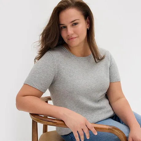 Grå, kortermet genser kombinert med bluejeans.