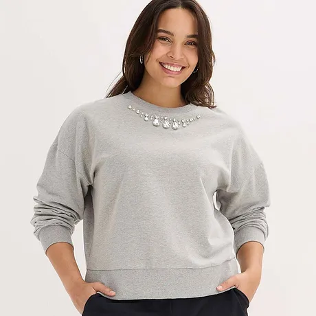 Grå sweatshirt med strasspynt ved kragen.