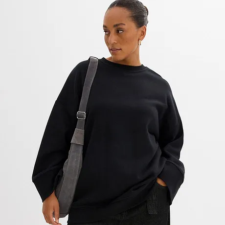 Sort sweatshirt med rund hals og grå skulderveske.