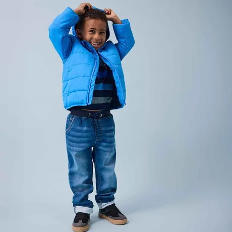 Blå dunjakke, stripete topp og jeans – herlig mote for barn på kalde dager.