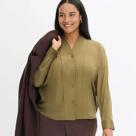 Elegant kombo bestående av olivengrønn bluse og brun kåpe.