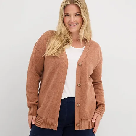 Rustfarget cardigan over hvit topp kombinert med mørke jeans.