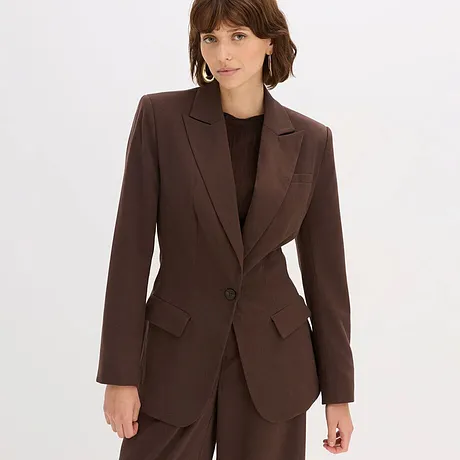 Brun blazer med sort topp under og brun bukse.