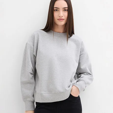 Stilren, grå sweatshirt med rund hals kombinert med mørk bukse.