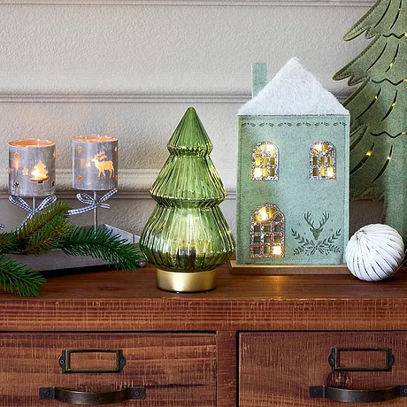 Festlig julebelysning med hus, lys og grønt juletre.