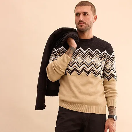 Mønstret, strikket genser i beige og sort.