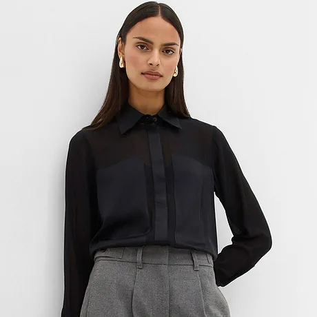 Sort bluse kombinert med grå bukse.