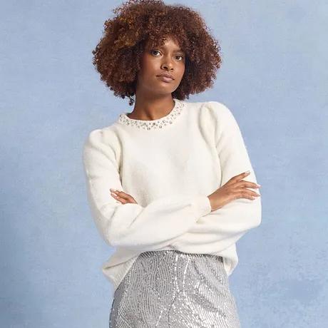 Hvit genser med blondekrage kombinert med glitrende, sølvfarget skjørt.