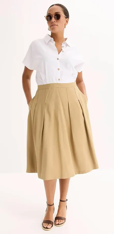 Elegant sommerlook: Hvit, kortermet skjorte kombinert med beige midiskjørt og sorte sandaler.