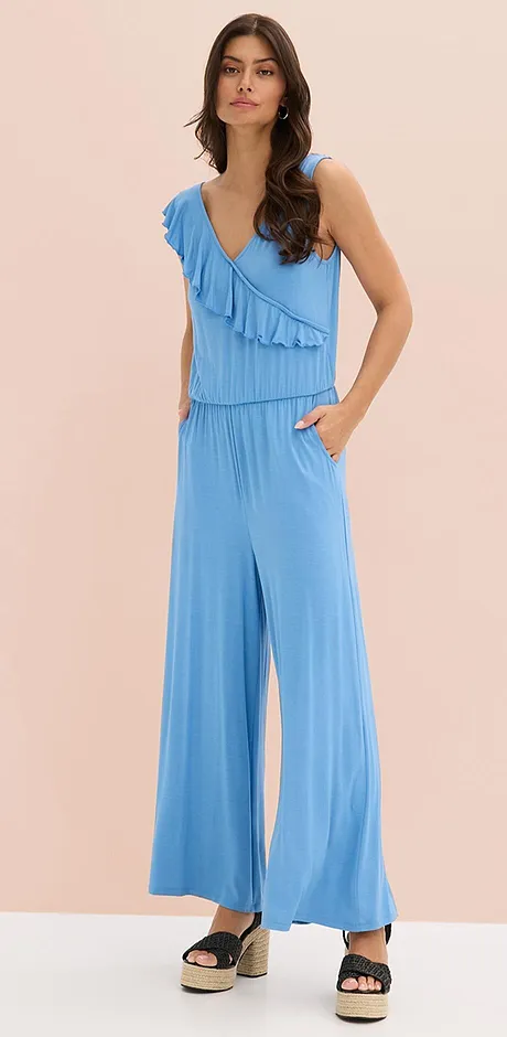 Lyseblå jumpsuit med rysjer, V-hals og vide ben. Luftig og lett sommerlig outfit for varme dager.