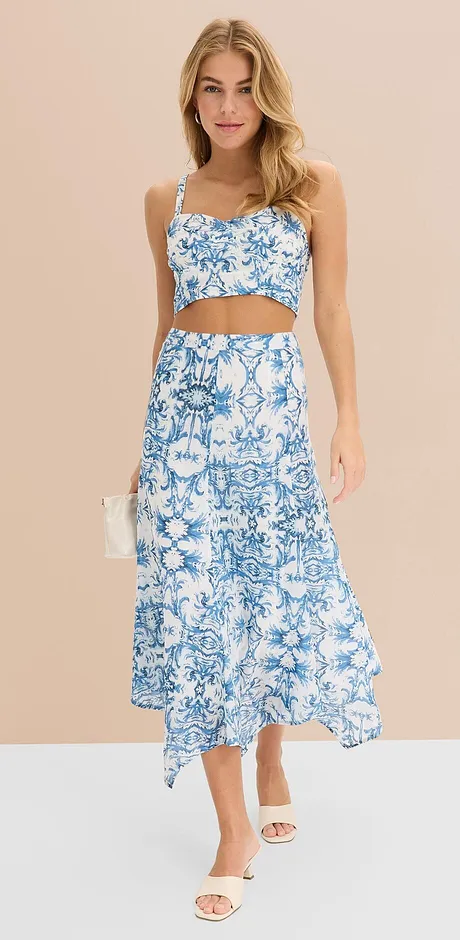 Sommerlig, todelt outfit med blått og hvitt blomstermønster: Crop topp og langt skjørt med asymmetrisk fald.