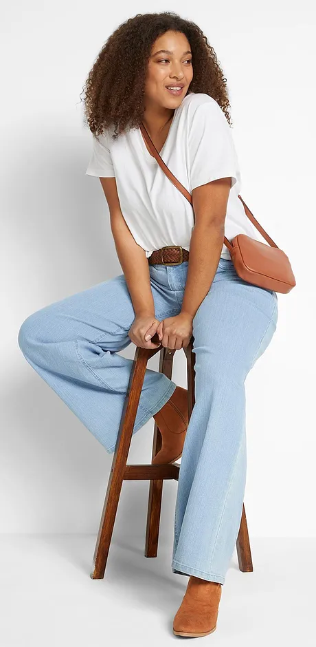 Hvit T-skjorte med vid utringning, lyse jeans og brun skinnveske.
