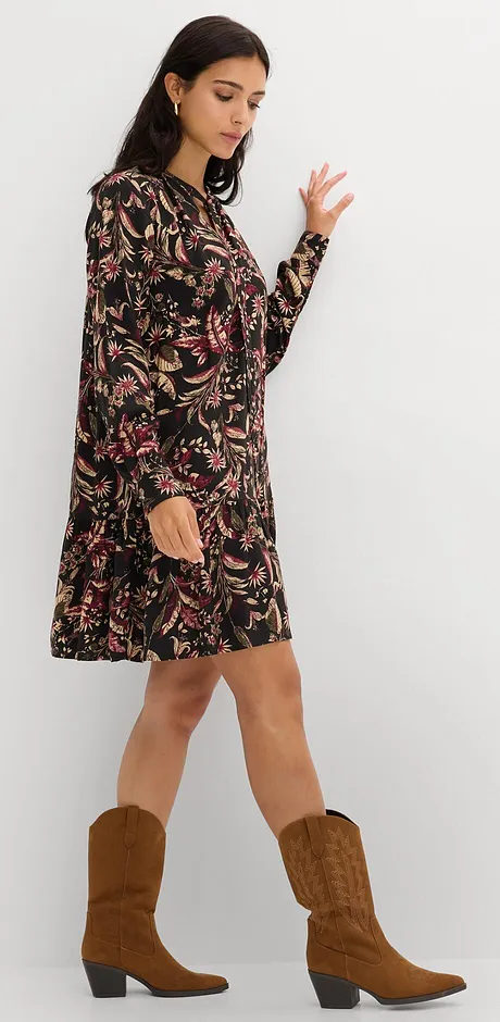 Sort kjole med blomstermønster kombinert med brune cowboyboots.