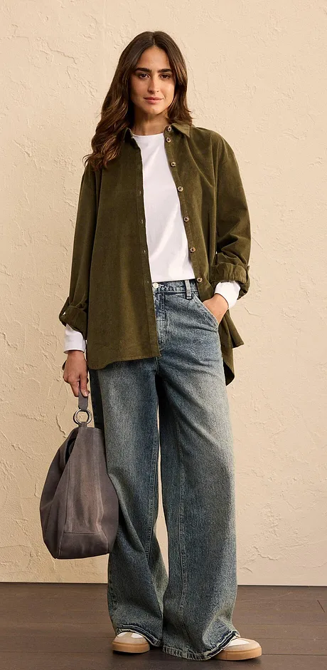 Look bestående av olivengrønn, oversized skjorte, hvit T-skjorte og vide jeans.
