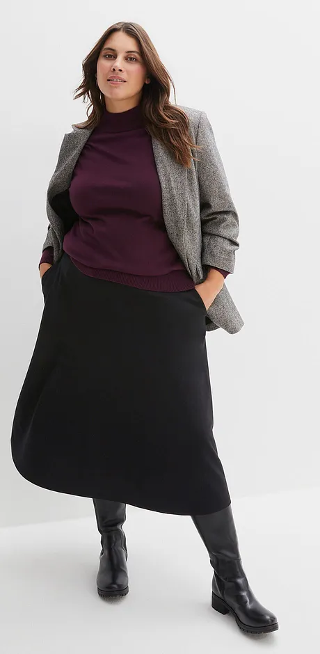 Grå blazer, lilla genser og langt, sort skjørt med sorte støvletter.