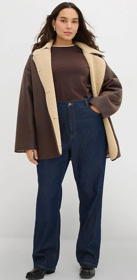 Brun jakke med lys krage kombinert med passende, mørk topp og jeans.