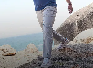 Lysegrå stoffbukse kombinert med lyse sneakers.