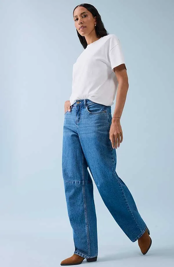 Klassisk hvit T-skjorte kombinert med vide jeans og brune sko.