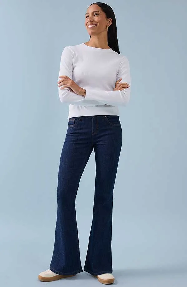 Hvit, langermet skjorte kombinert med m&oslash;rkebl&aring; slengbukse for en tidl&oslash;s, elegant look.