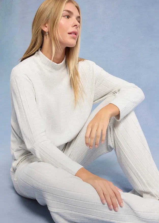 Elegant, hvit strikkegenser med st&aring;krage perfekt kombinert med matchende hvit bukse.