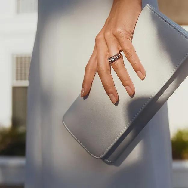 Hvit kjole kombinert med lys clutch og nydelig ring.