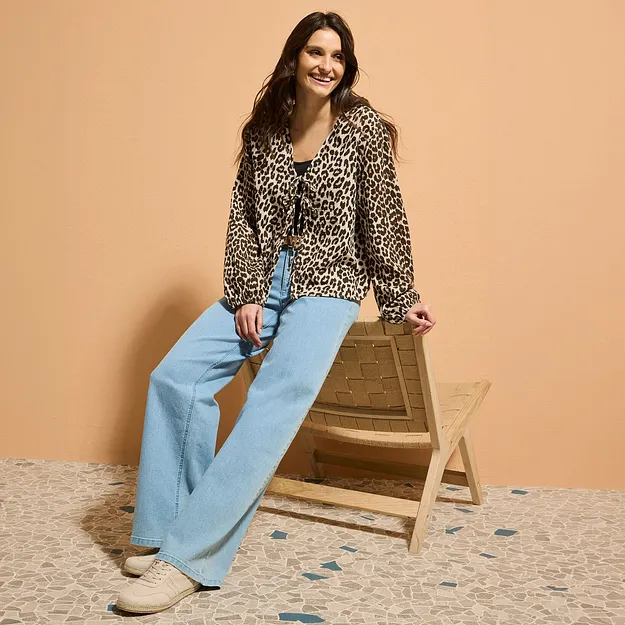 Leopardm&oslash;nstret bluse m&oslash;ter lysebl&aring; jeans med sleng.