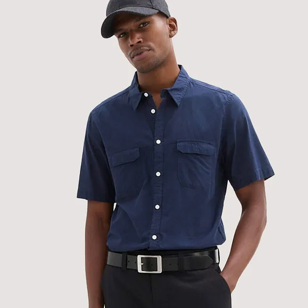 Bl&aring;, kortermet skjorte i 100% bomull med brystlommer.