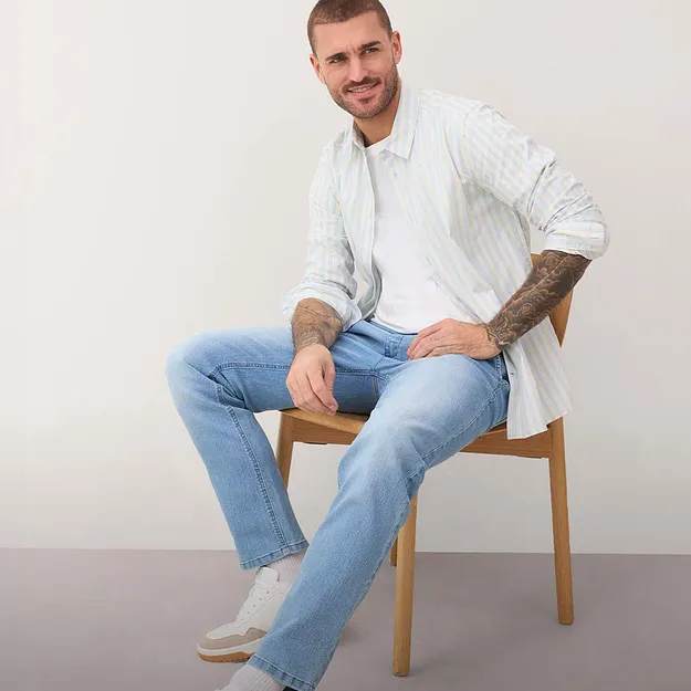 Lys, m&oslash;nstret skjorte, bluejeans og hvite sneakers.