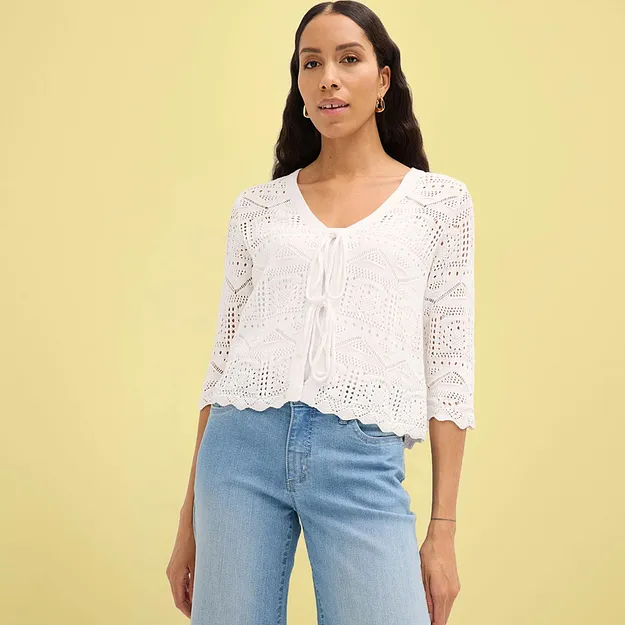 Hvit cardigan i heklet stil med korte ermer kombinert med bluejeans.