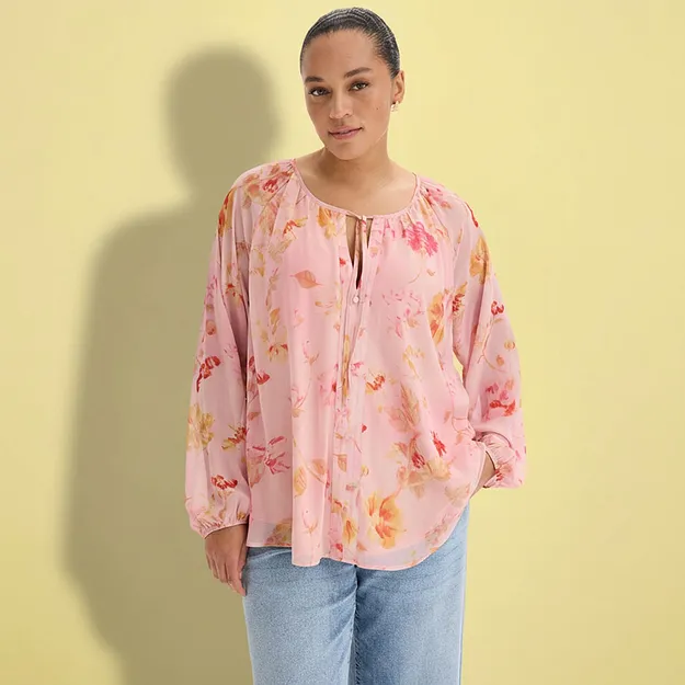 En rosa bluse med blomsterprint og avslappede jeans.