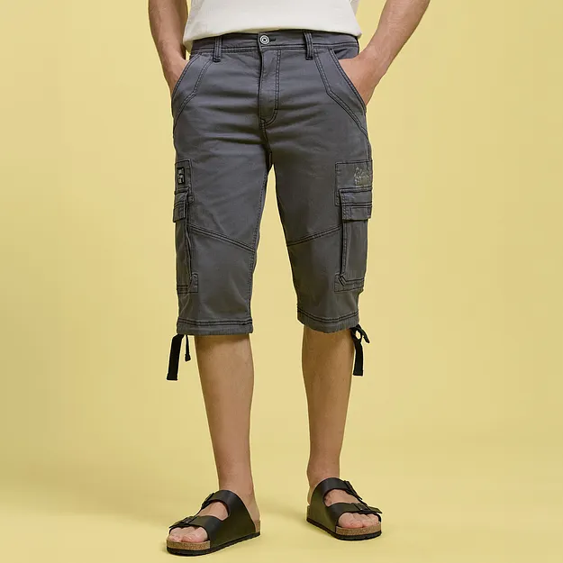 Gr&aring; cargoshorts med praktiske sidelommer, hvit T-skjorte og sorte sandaler.