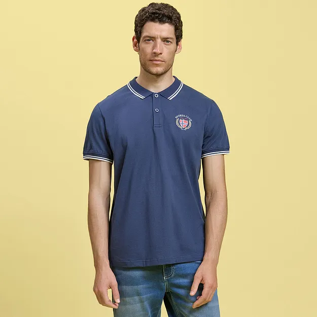 Sporty, bl&aring; poloskjorte med logo kombinert med avslappet denimshorts.