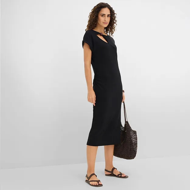 Elegant, sort midikjole med asymmetrisk utringning og matchende, sort veske.