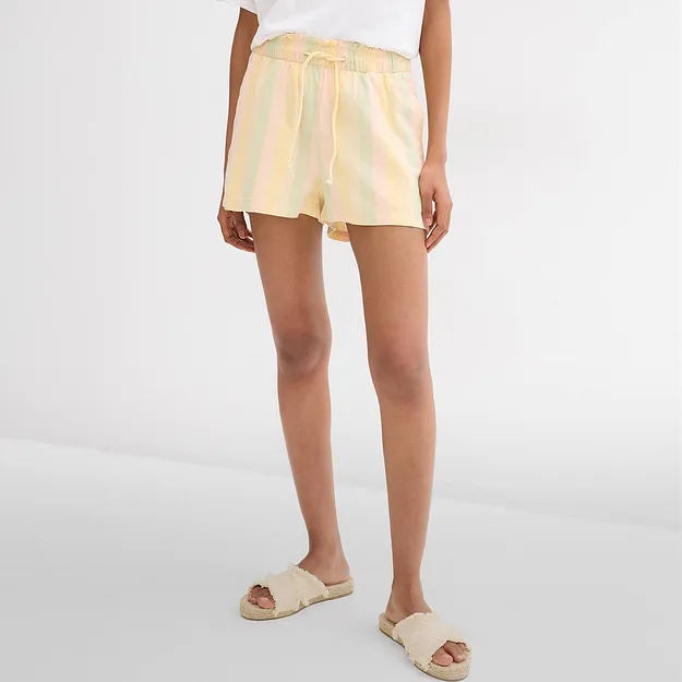 Shorts med pastellfargede striper, hvit T-skjorte og behagelige bastsandaler for varme dager.