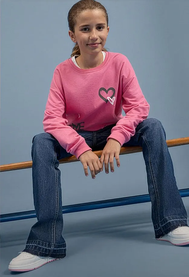 Kult antrekk: Rosa, langermet topp med hjerte, vide jeans og behagelige, hvite sneakers.